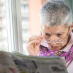 elderly lady reading newspaper