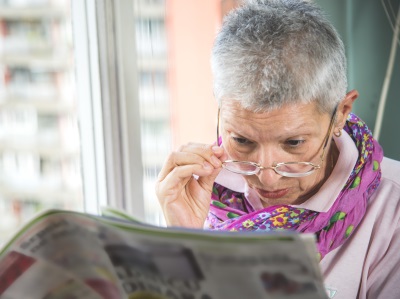elderly lady reading newspaper